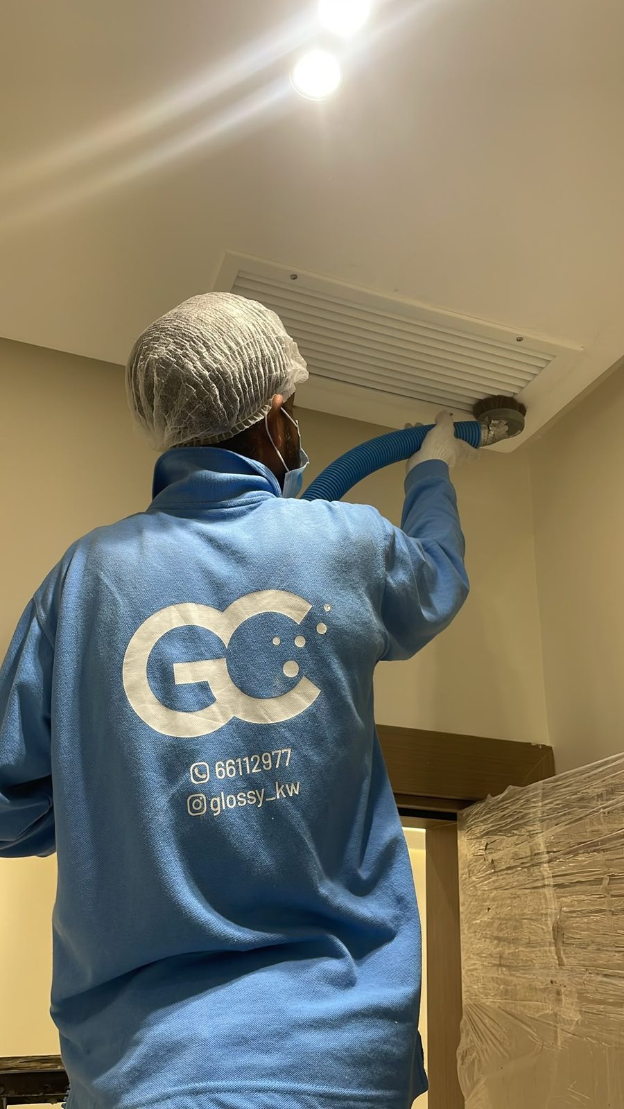 A Glossy technician cleaning an A/C vent